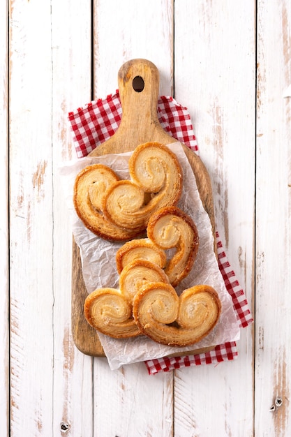 Bezpłatne zdjęcie ciasto francuskie palmier w talerzu na białym drewnianym stole