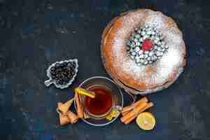 Bezpłatne zdjęcie ciasto owocowe z widokiem z góry pyszne i okrągłe uformowane ze świeżego błękitu, jagód i wraz z filiżanką herbaty na ciastku ciastka ze słodkim cukrem
