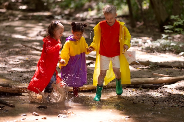 Bezpłatne zdjęcie ciekawskie dzieci uczestniczące w poszukiwaniu skarbów w lesie