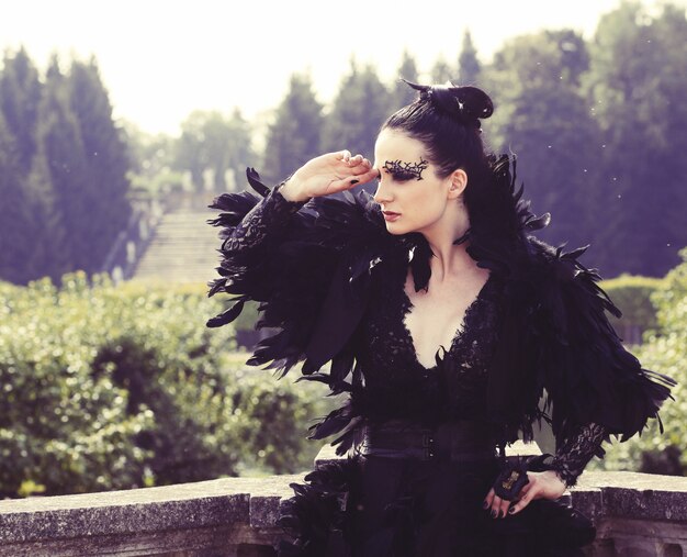 Ciemna królowa w parku. czarna sukienka fantasy.