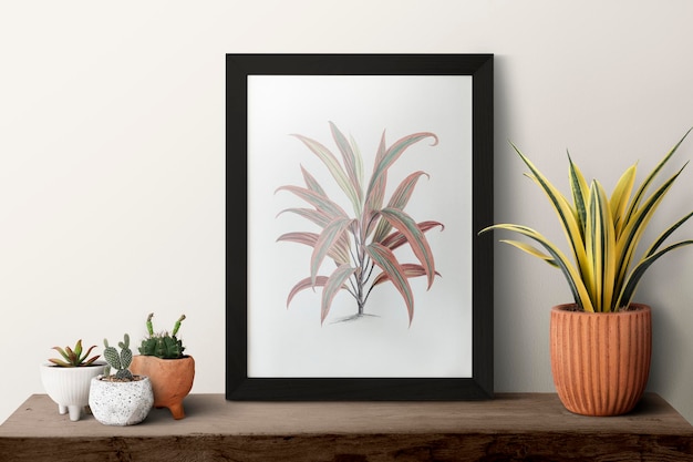 Bezpłatne zdjęcie ciemna nowoczesna ramka na zdjęcia na półce z roślinami