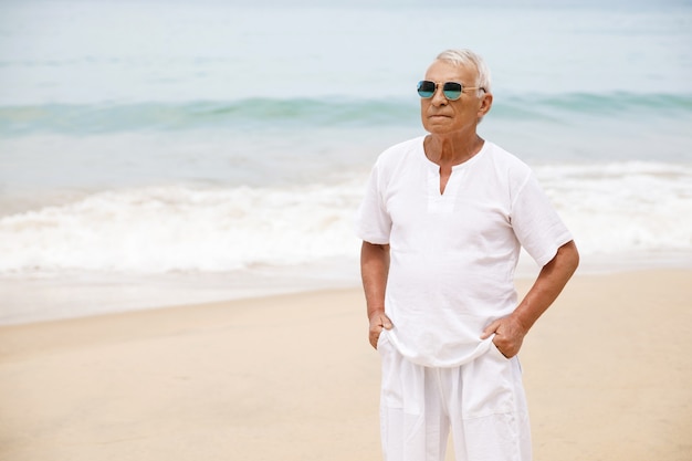 Cieszyć się emeryturą. szczęśliwy starszy mężczyzna spaceru na plaży.