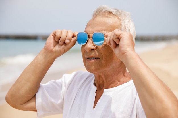 Cieszyć się emeryturą. szczęśliwy starszy mężczyzna spaceru na plaży.