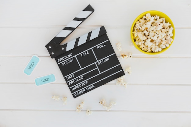 Clapperboard między miska popcorn i bilety