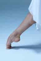 Bezpłatne zdjęcie close-up baleriny noga na niebieskiej podłodze