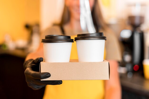 Close-up barista z rękawiczkami serwującymi kawę