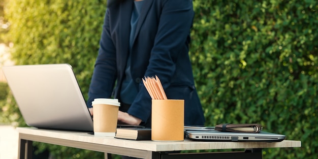 Close-up businesswoman pisania dokumentów na klawiaturze laptopa trzyma fili? Ank? Kawy i dzia? Alno? Ci osób pracuj? Cych w tle. Selektywnym. Efekt filmu i efekt odblasku słonecznego