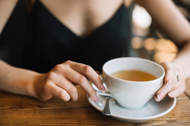 Close-up kobiety ręka trzyma herbacianą filiżankę