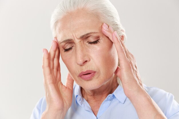 Close-up portret starszej pani z bólem głowy