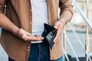Bezpłatne zdjęcie close-up ręce trzymając portfel i monety