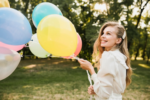 Close-up smiley urodziny dziewczyny z balonami