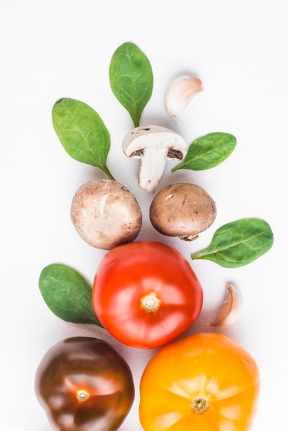 Close-up szpinak i czosnek w pobliżu pomidorów i grzybów
