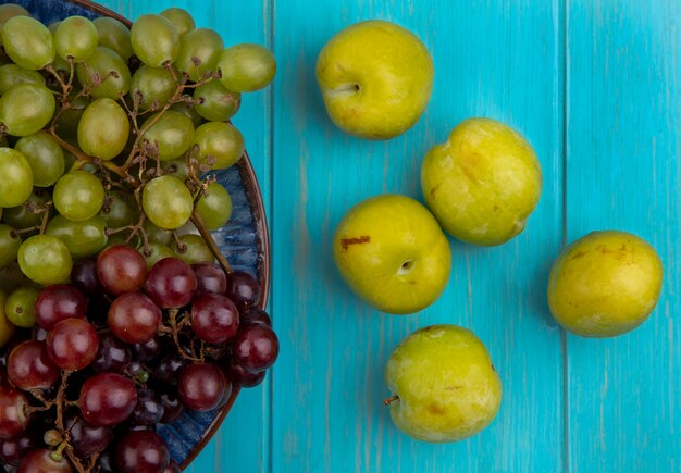 Close-up widok owoców jak winogrona w płycie i wzór zielonych działek na niebieskim tle