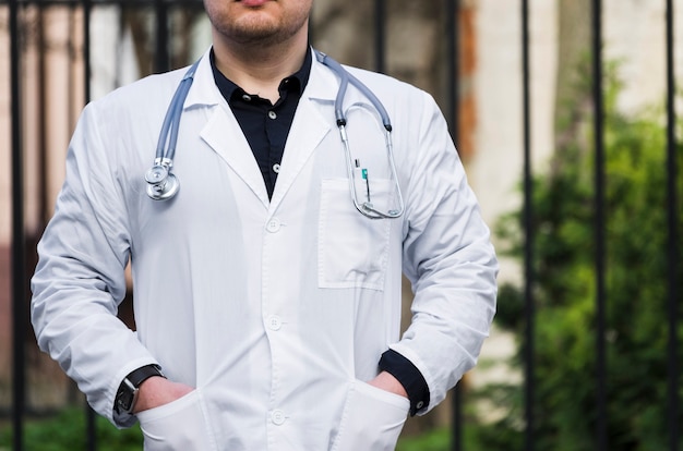 Close-up z męskiego lekarza ze stetoskopem na szyi na zewnątrz