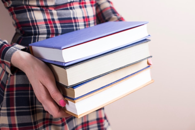 Close-up z rąk z czterech grubych książek