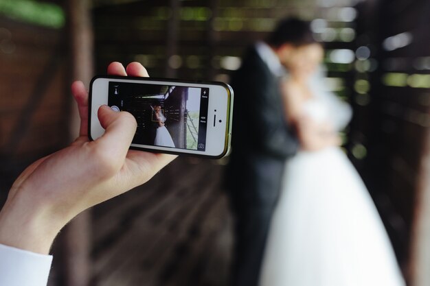 Close-up z telefonu komórkowego robi zdjęcie nowożeńców