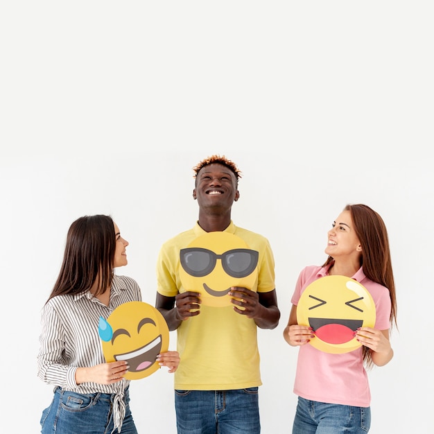 Copy-space młodzi przyjaciele trzyma emoji
