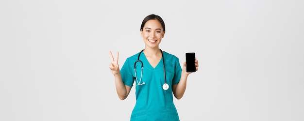 Covid pracownicy opieki zdrowotnej i koncepcja medycyny online uśmiechnięta pewna siebie azjatycka lekarka lekarz...