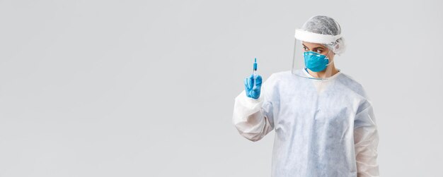 Covid19 badania medyczne diagnoza pracownicy służby zdrowia i koncepcja kwarantanny Profesjonalny lekarz w sprzęcie ochrony osobistej Kostium PPE trzymający strzykawkę ze szczepionką na koronawirusa