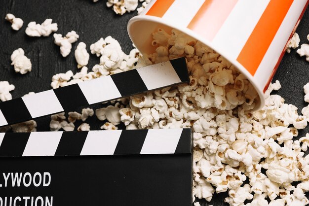 Crop clapperboard w pobliżu wiadro popcorn