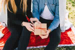 Bezpłatne zdjęcie crop couple with gift box outside