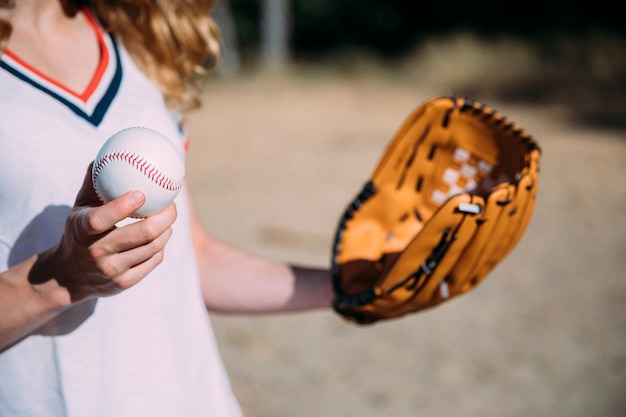 Crop female utrzymuje baseball i rękawicę