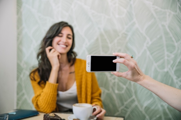 Crop hand taking picture of woman