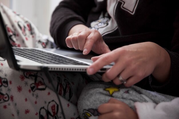 Crop matka i córka za pomocą laptopa