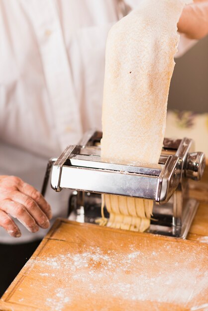 Crop person cutting pasta