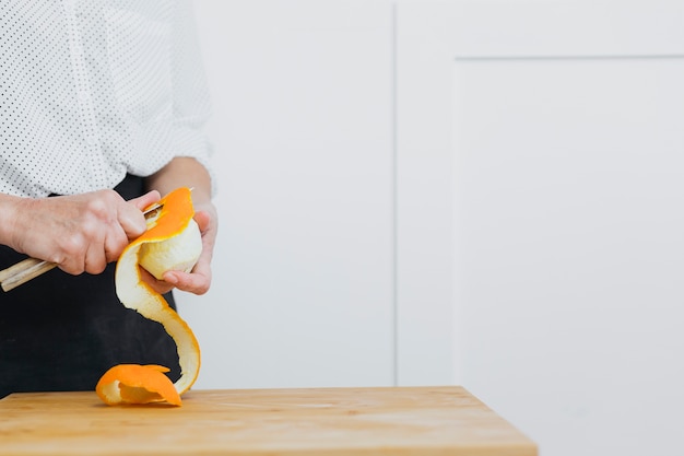 Bezpłatne zdjęcie crop person peeling orange