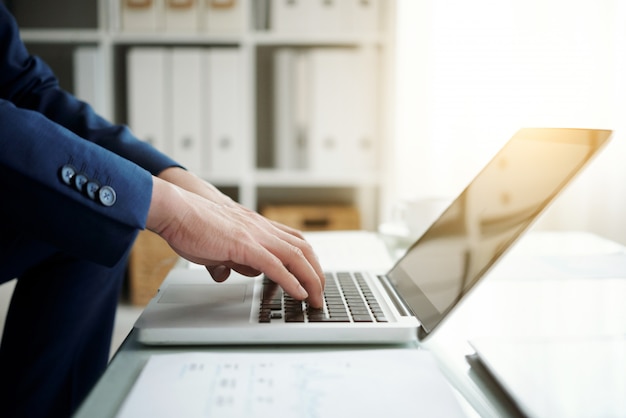 Cropped boczny widok anonimowy biznesmen pracuje na laptopie