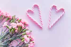 Bezpłatne zdjęcie cukierki laski w kształcie serca z kwiatami