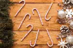 Bezpłatne zdjęcie cukierki między świątecznymi dekoracjami i iglastymi gałąź