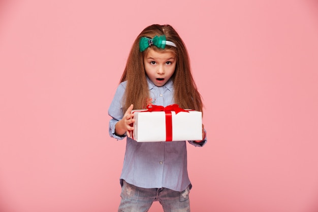 Bezpłatne zdjęcie cute girl gospodarstwa pudełko z otwartymi ustami jest podekscytowany i zaskoczony, aby uzyskać prezent urodzinowy