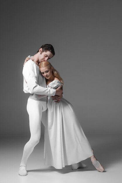 Ćwiczenia dwóch młodych tancerzy baletowych. atrakcyjnych wykonawców tańca w kolorze białym