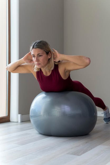 Bezpłatne zdjęcie Ćwiczenia z piłką fitness w pomieszczeniu