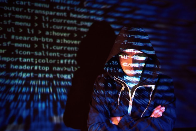 Cyberatak z nierozpoznawalnym hakerem z kapturem wykorzystującym wirtualną rzeczywistość, cyfrowy efekt usterki