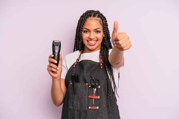 Czarna afro kobieta czuje się dumna, uśmiecha się pozytywnie z kciukami do góry. koncepcja fryzjera