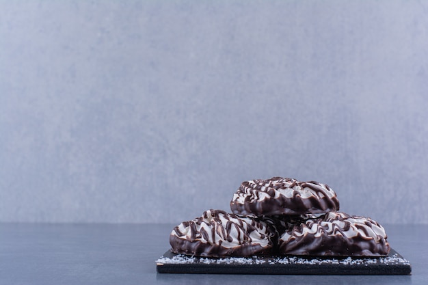 Czarna drewniana tablica słodkich ciasteczek na kamiennej powierzchni