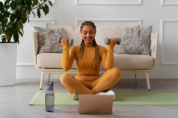 Bezpłatne zdjęcie czarna kobieta robi fitness w domu