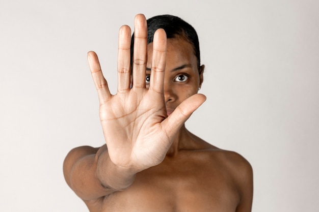 Bezpłatne zdjęcie czarna kobieta z nagą klatką piersiową robi gest zatrzymania ręki