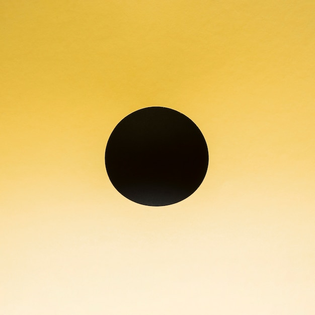 Czarne koło na gradientowym żółtym tle