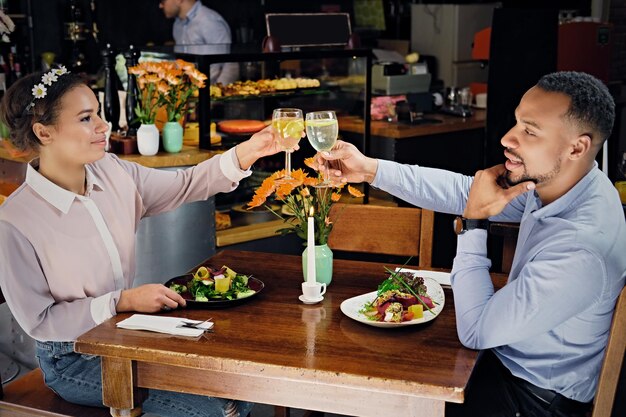 Czarny amerykański para na randkę, pić wino w restauracji.