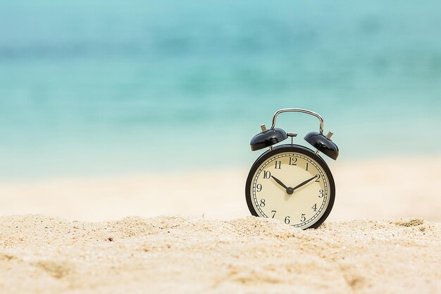 Czas na wakacje koncepcja budzik na tropikalnej plaży