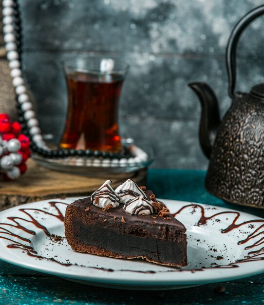 czekoladowe brownie przyozdobione śmietaną i startą czekoladą