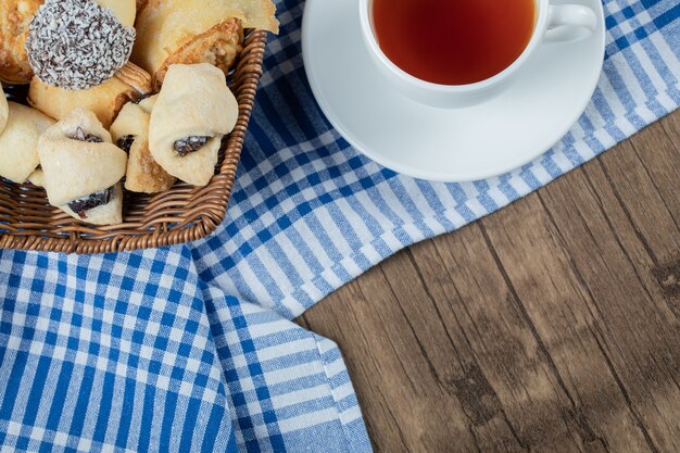Czekoladowe ciasteczka sezamowe w drewnianym koszyczku z filiżanką herbaty Earl Grey.