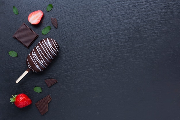 Bezpłatne zdjęcie czekoladowe i truskawkowe lody na czerń stole