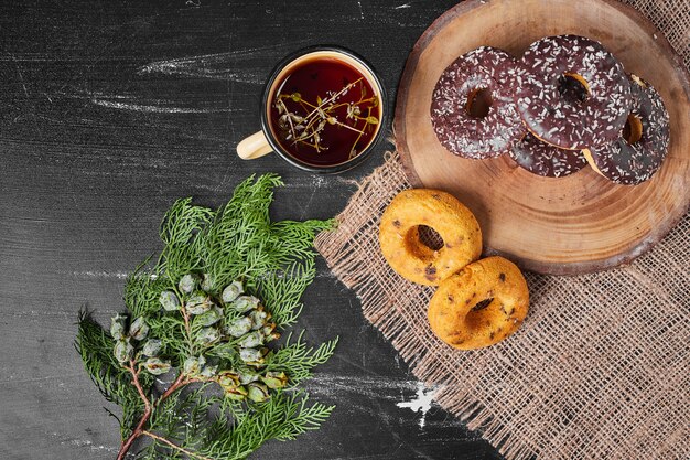 Czekoladowe pączki na drewnianym talerzu z herbatą.