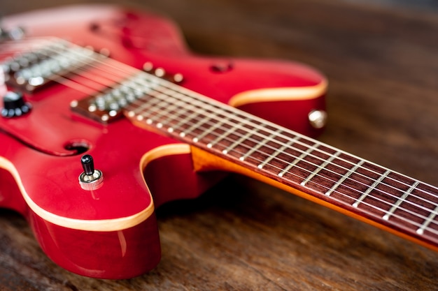 Czerwona gitara elektryczna na drewnianej podłoga