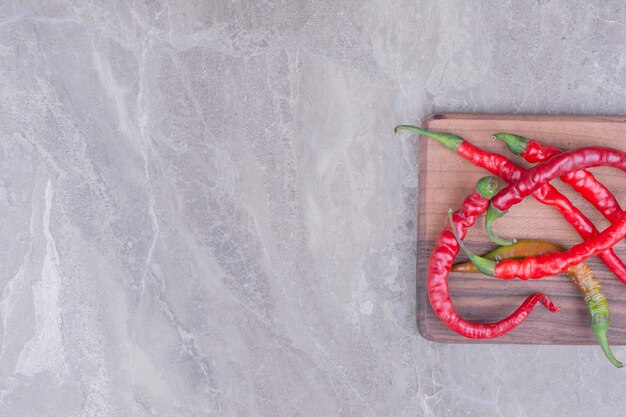 Czerwona papryka chili na białym tle na drewnianej desce na powierzchni marmuru